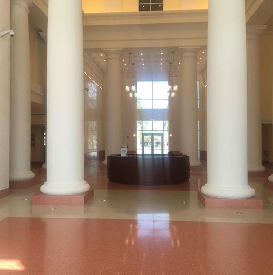 A large room with two pillars and a couch.