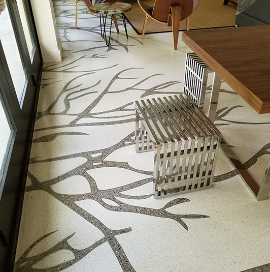 A room with a table and chairs, and a tree branch pattern on the floor.