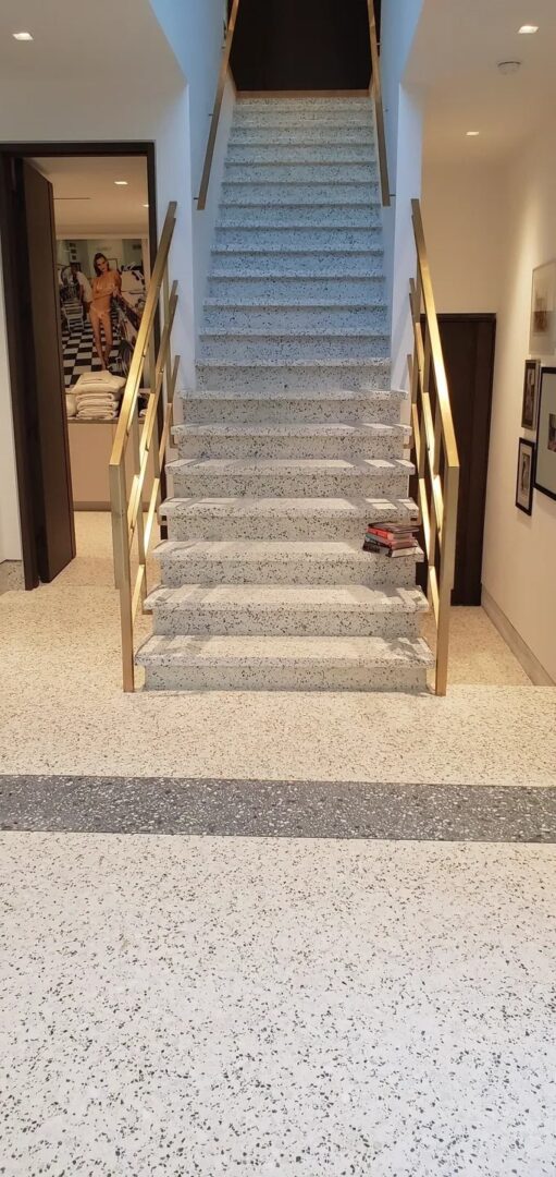 A staircase with gold handrails and carpet on the bottom.