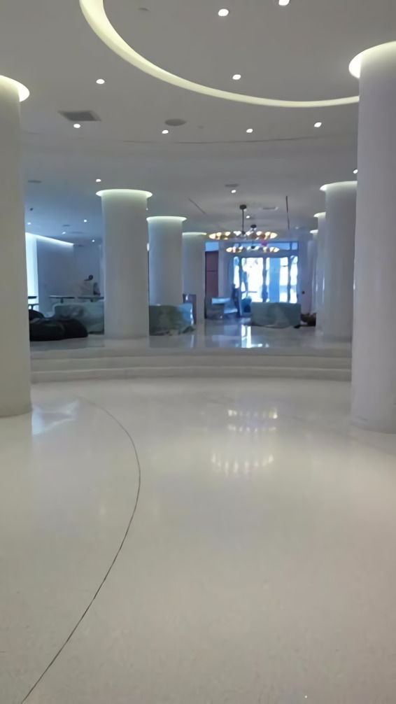 A large white room with pillars and lights