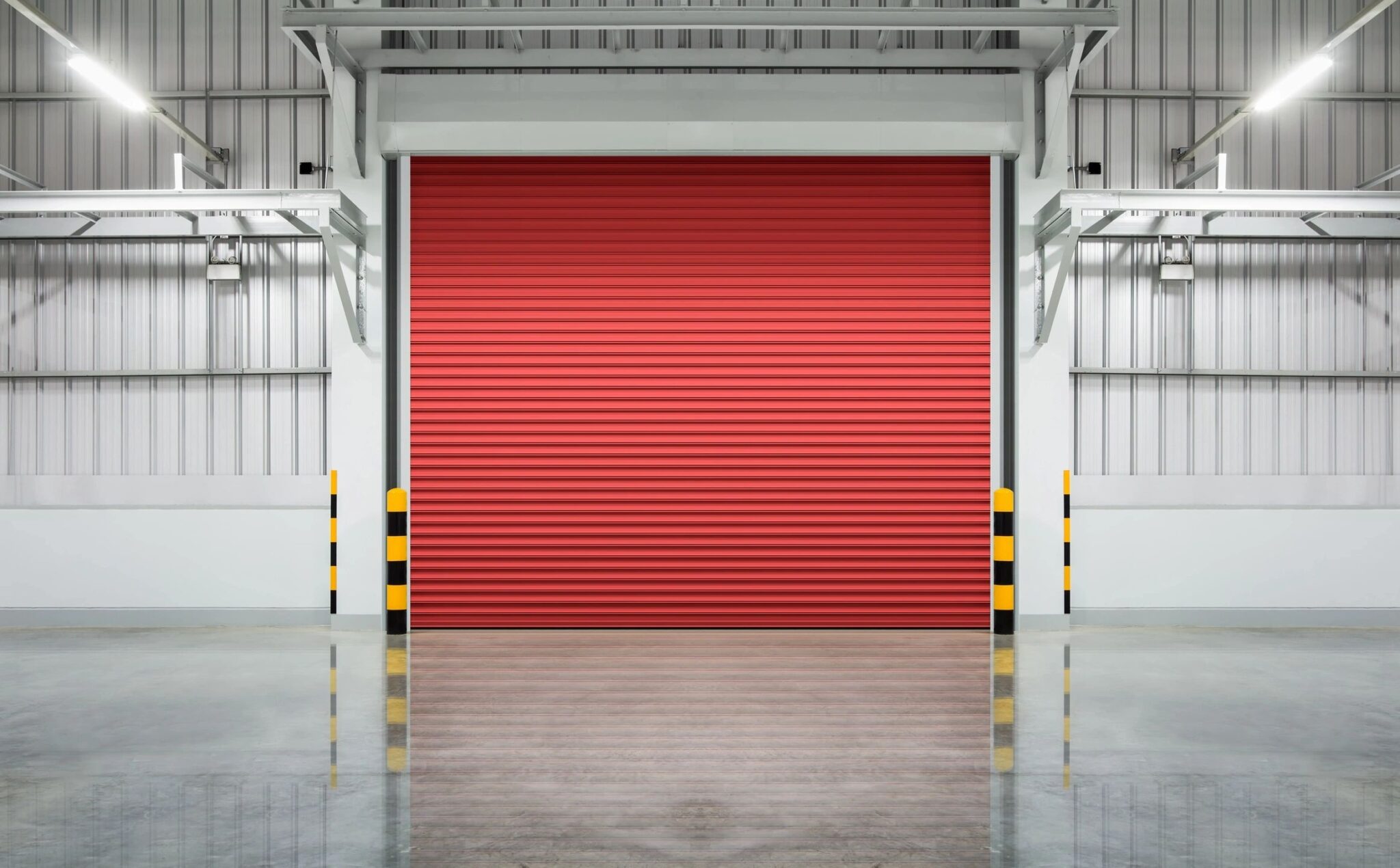 A red garage door in an industrial building.