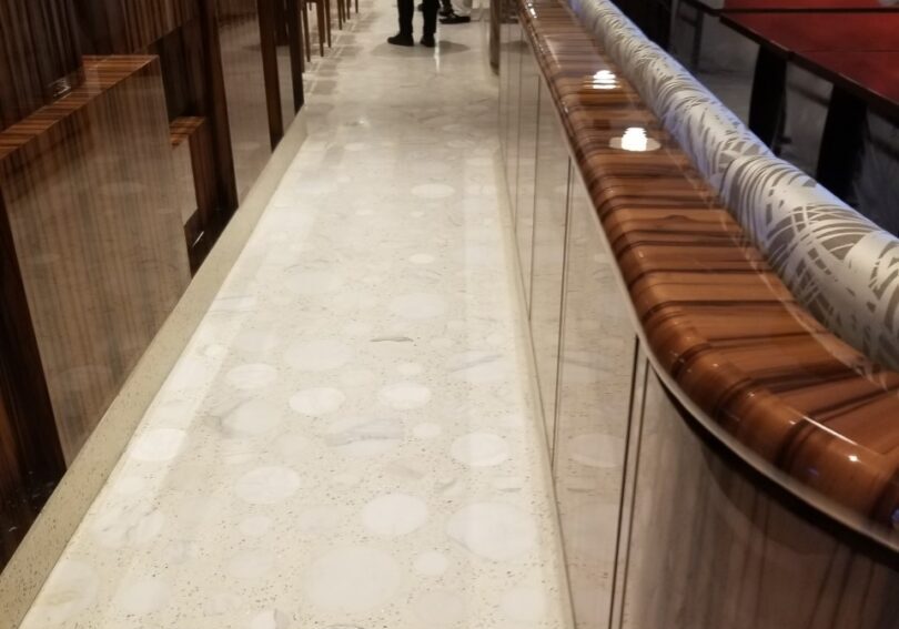 A person walking down the hall way of a restaurant.